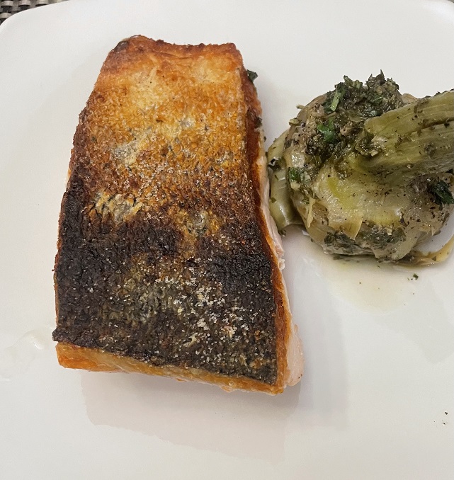 A piece of salmon with Brussel sprouts.

Description automatically generated with medium confidence